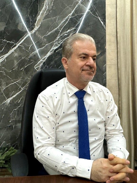 دکتر بختیاری با پیراهن خال‌خالی و کراوات آبی