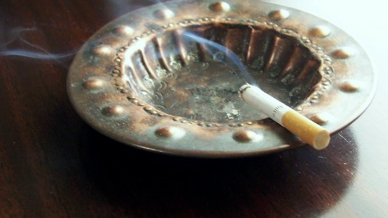 سیگار روشن در زیرسیگاری فلزی، دود کم